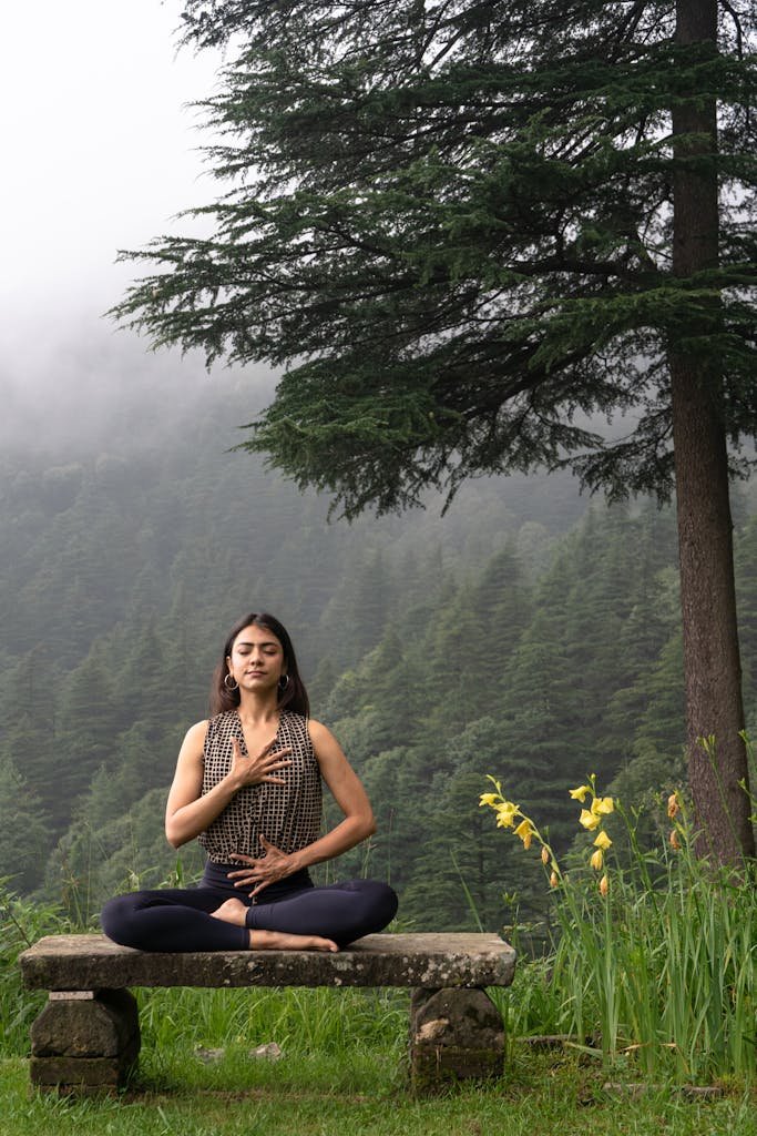 Woman practicing meditation in serene forest environment,